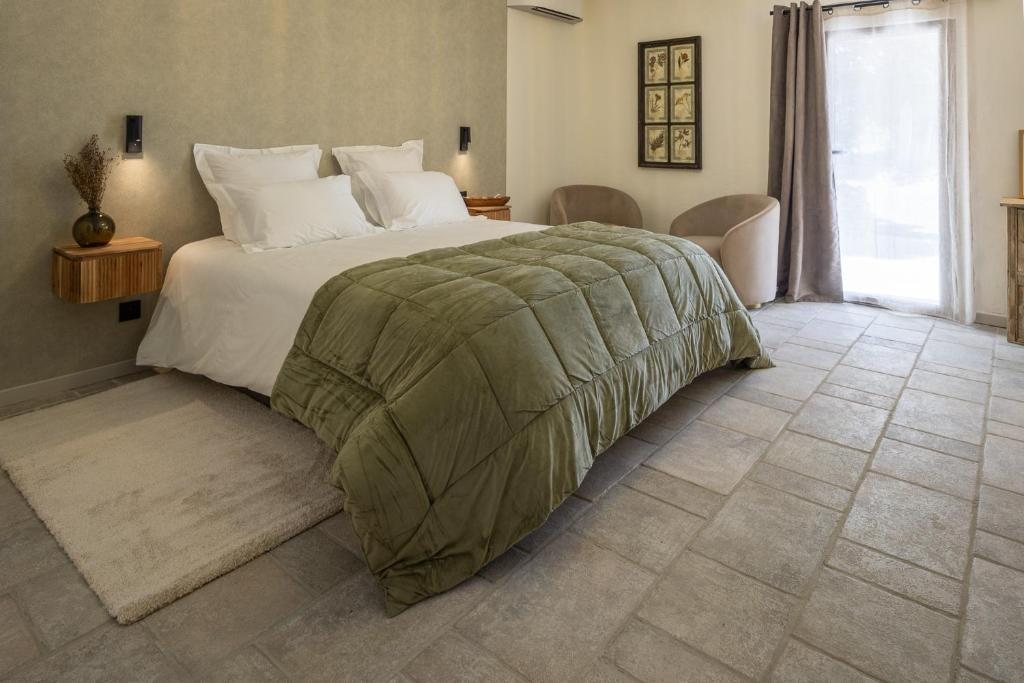 Deluxe Room N. 3 — le duvet vert profond sur sol de pierre